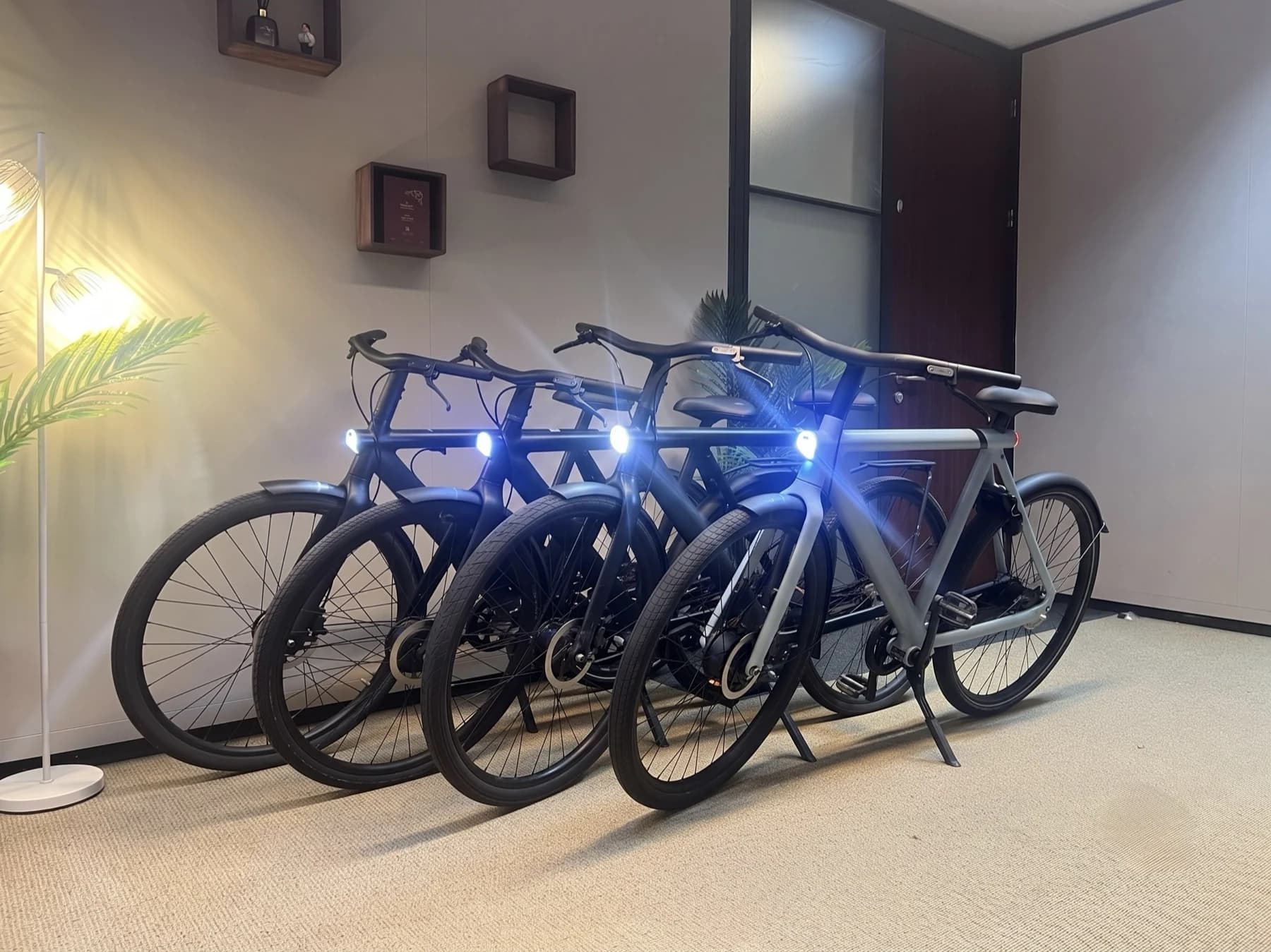 Four refurbished VanMoof S3 and X3 bikes lined up in the MME workshop in Amsterdam