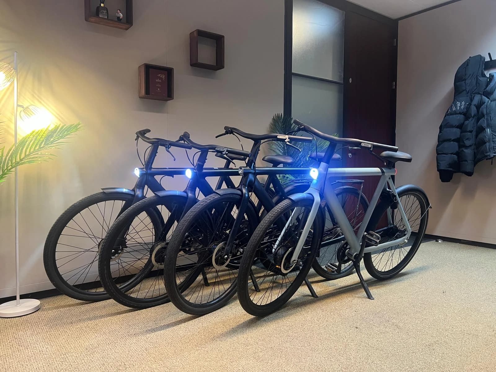 Four refurbished VanMoof S3 and X3 bikes lined up in the MME workshop in Amsterdam